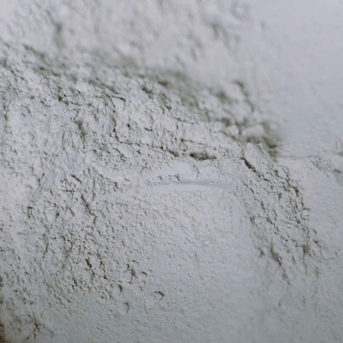 A close-up view of starch powder, displaying its fine, white texture and scattered piles against a neutral background. The powder appears soft and smooth, with subtle shadows and highlights enhancing its volume.